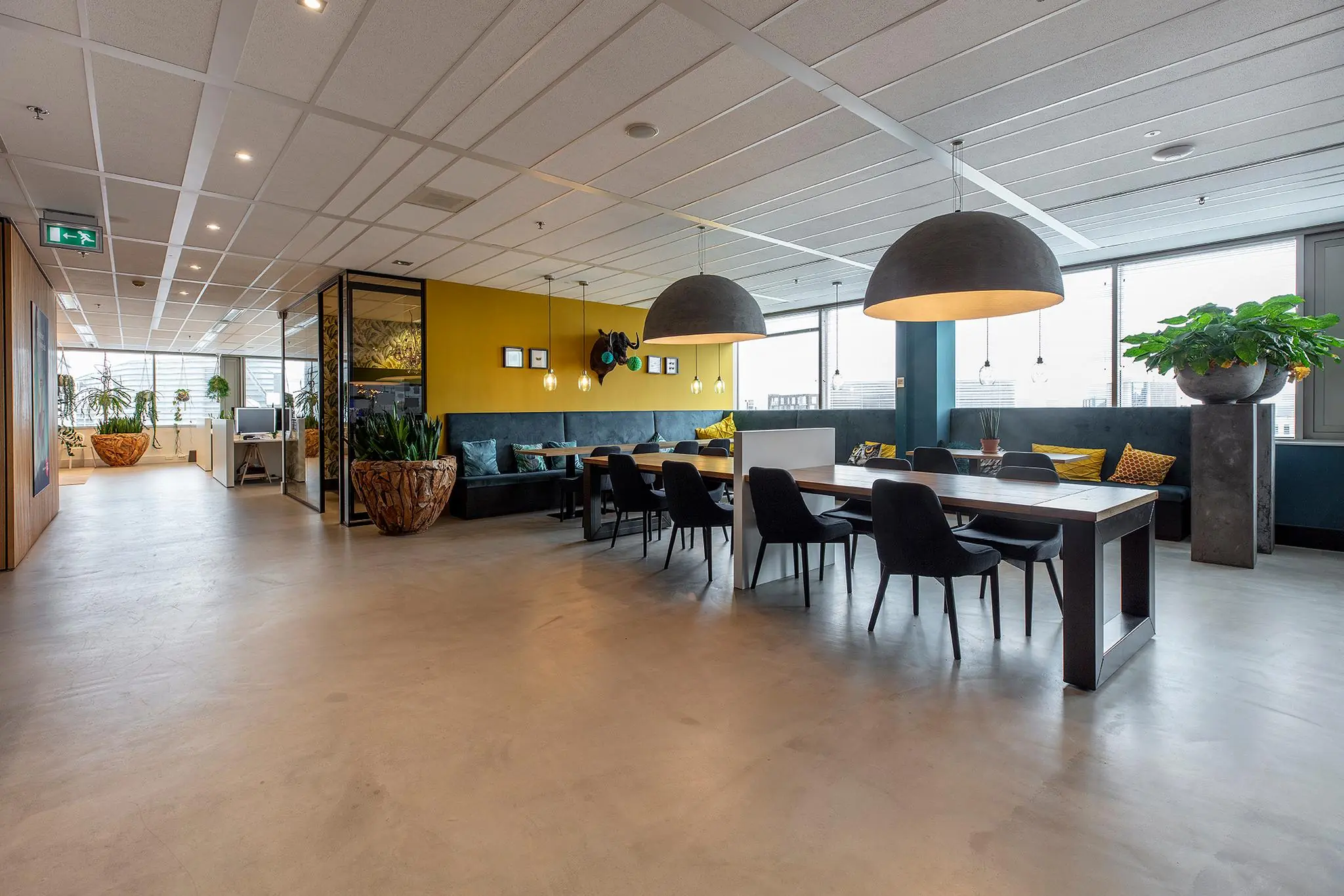 Moderne en sfeervolle kantoorruimte aan de Vliegend Hertlaan met zithoeken, vergadertafel en veel natuurlijke elementen.